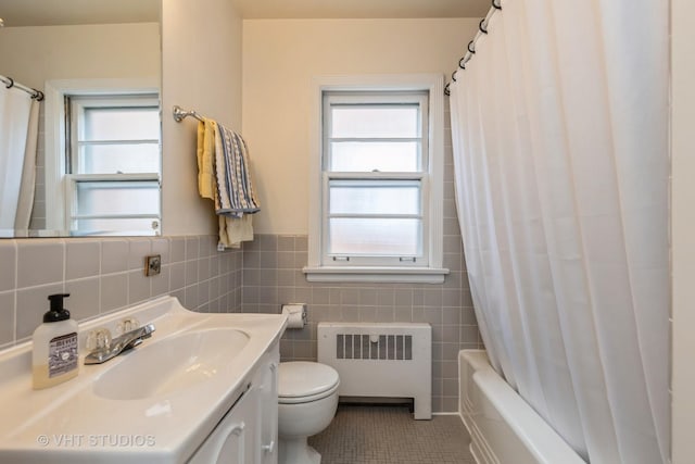 full bathroom featuring radiator, tile walls, vanity, toilet, and tile patterned floors