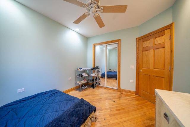 bedroom with ceiling fan, a closet, and light hardwood / wood-style flooring