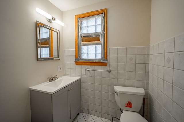 bathroom featuring tile patterned flooring, vanity, tile walls, and toilet