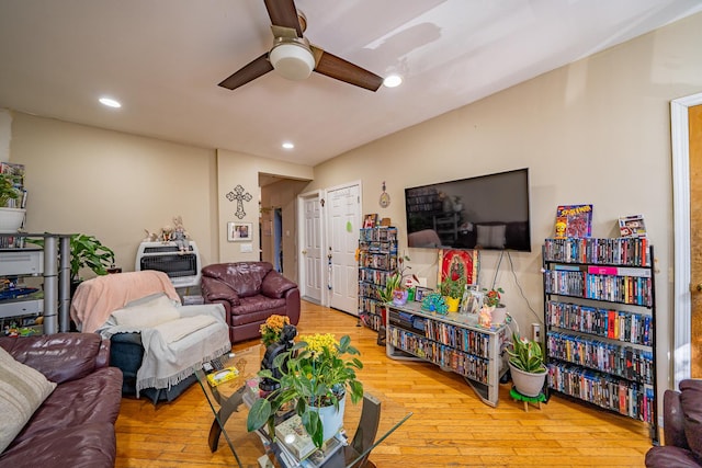 living room featuring ceiling fan, light hardwood / wood-style floors, and heating unit