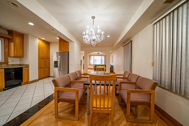 tiled dining room with a chandelier