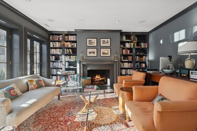 living area featuring crown molding and built in shelves