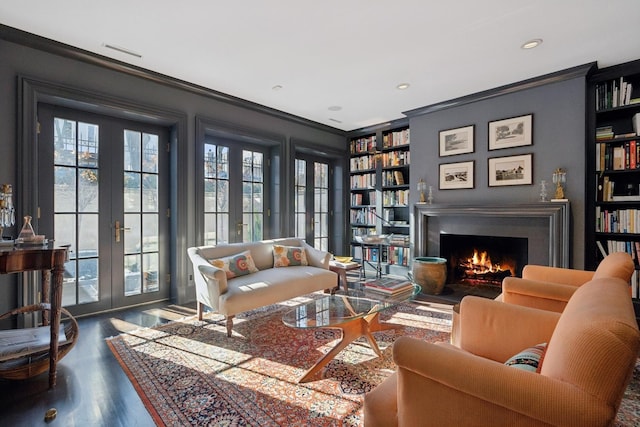 sitting room featuring crown molding, dark wood-type flooring, a wealth of natural light, and french doors