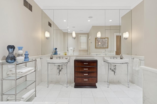 bathroom featuring crown molding, dual sinks, and tile patterned floors