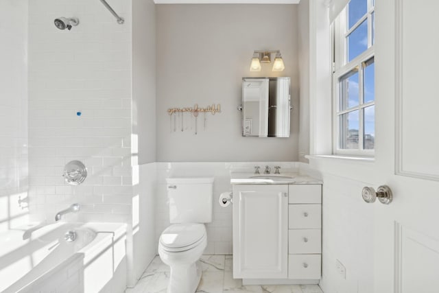 full bathroom featuring tiled shower / bath combo, vanity, tile walls, and toilet