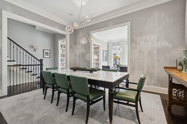 dining space featuring crown molding, wood-type flooring, and a chandelier