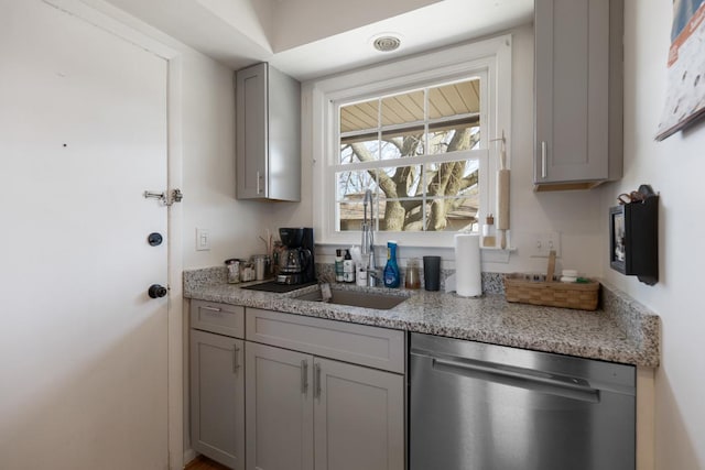 kitchen featuring gray cabinets, dishwasher, sink, and light stone countertops