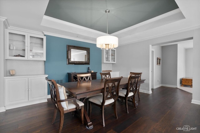 dining space featuring a raised ceiling, ornamental molding, and dark hardwood / wood-style floors