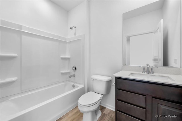 full bathroom with vanity, wood-type flooring, toilet, and washtub / shower combination