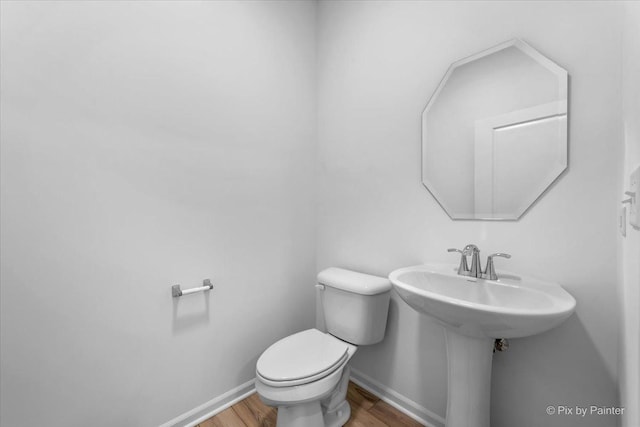 bathroom with hardwood / wood-style flooring and toilet