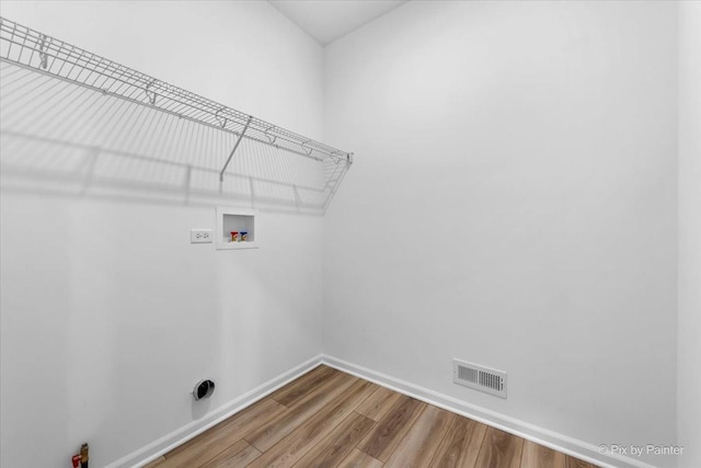 laundry room with hardwood / wood-style flooring and washer hookup