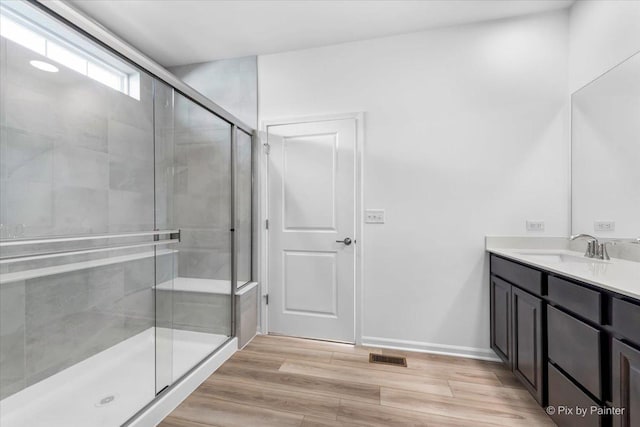 bathroom with vanity, hardwood / wood-style flooring, and walk in shower