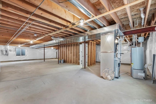 basement featuring electric panel, heating unit, and gas water heater