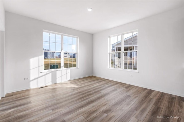 spare room featuring light hardwood / wood-style flooring and a wealth of natural light