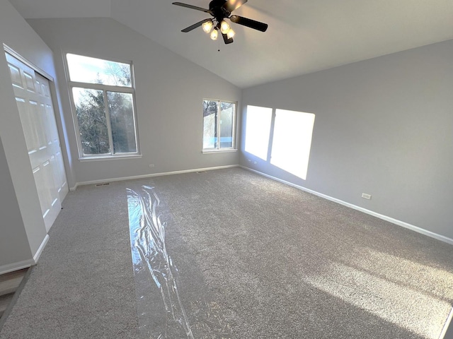 carpeted spare room featuring lofted ceiling and ceiling fan