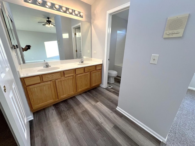 bathroom with vanity, hardwood / wood-style floors, toilet, and ceiling fan