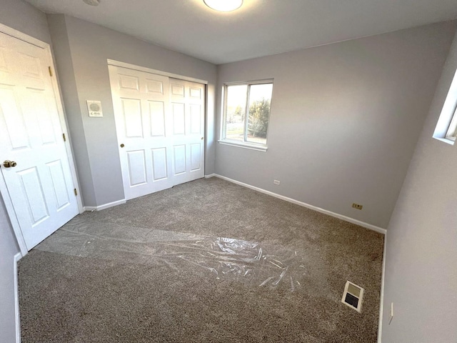 unfurnished bedroom featuring carpet flooring and a closet