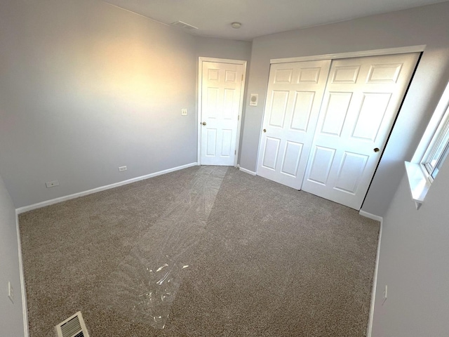 unfurnished bedroom featuring carpet flooring and a closet