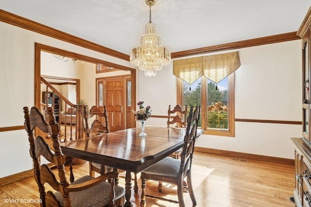 dining room with an inviting chandelier, crown molding, and light hardwood / wood-style flooring