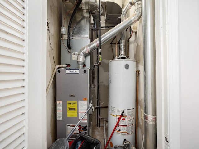 utility room featuring heating unit and water heater