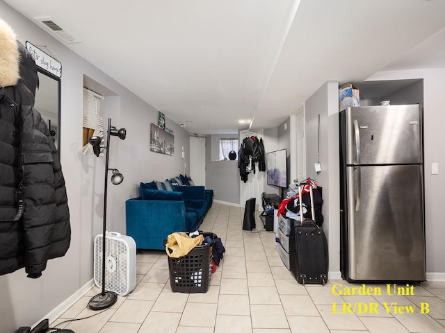 interior space featuring light tile patterned floors and stainless steel refrigerator