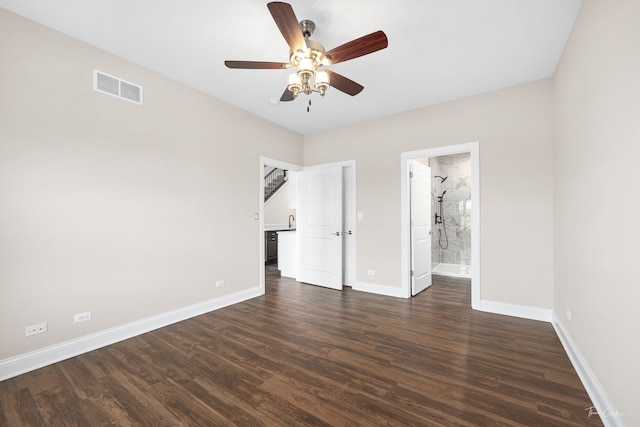 unfurnished bedroom featuring dark hardwood / wood-style floors, ceiling fan, and connected bathroom