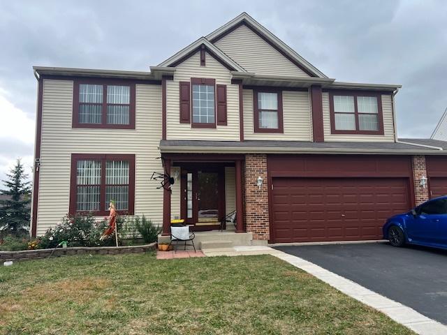 view of front of house with a garage and a front lawn