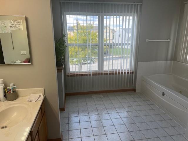 bathroom featuring vanity, tile patterned floors, and a tub to relax in