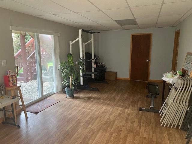 workout room featuring wood-type flooring and a drop ceiling