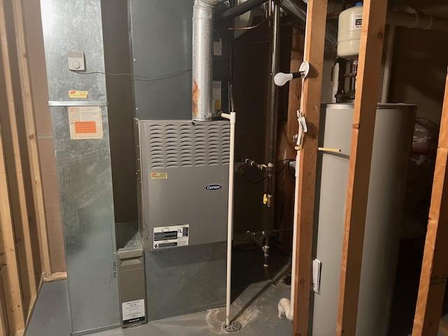 utility room with heating unit and water heater