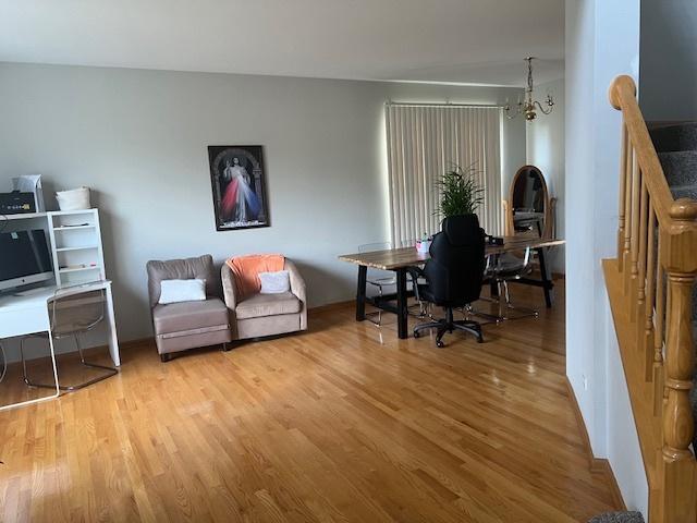 office space with an inviting chandelier and light hardwood / wood-style floors