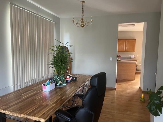 office with an inviting chandelier and light hardwood / wood-style flooring