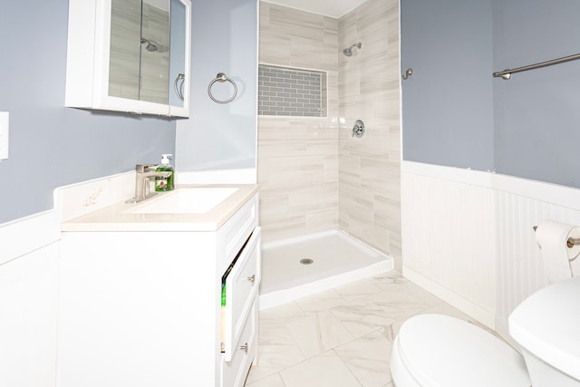 bathroom with vanity, toilet, and tiled shower