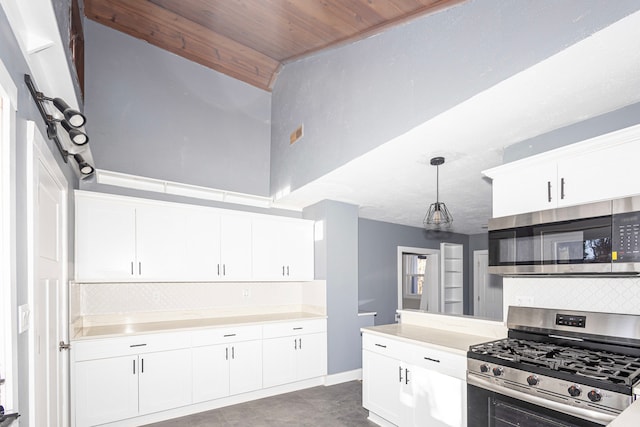 kitchen with pendant lighting, wood ceiling, appliances with stainless steel finishes, a high ceiling, and white cabinets