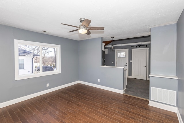 unfurnished living room featuring ceiling fan, dark hardwood / wood-style floors, and a textured ceiling