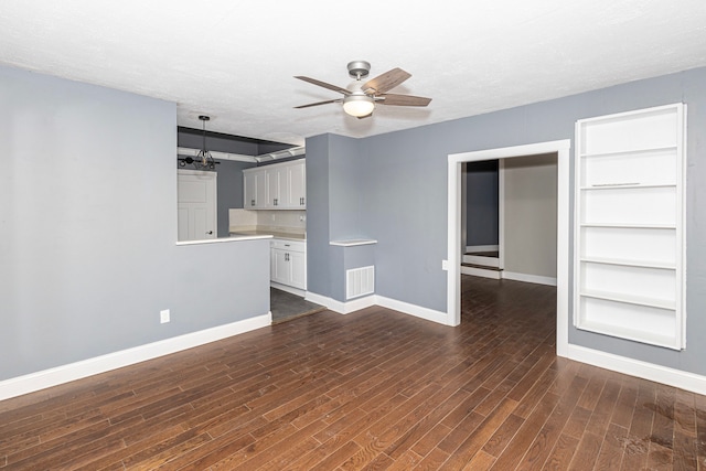 unfurnished living room featuring dark hardwood / wood-style flooring, ceiling fan, built in features, and a textured ceiling