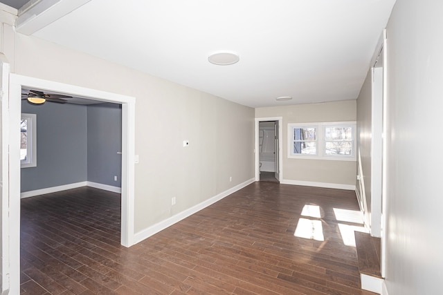 spare room with dark wood-type flooring and ceiling fan