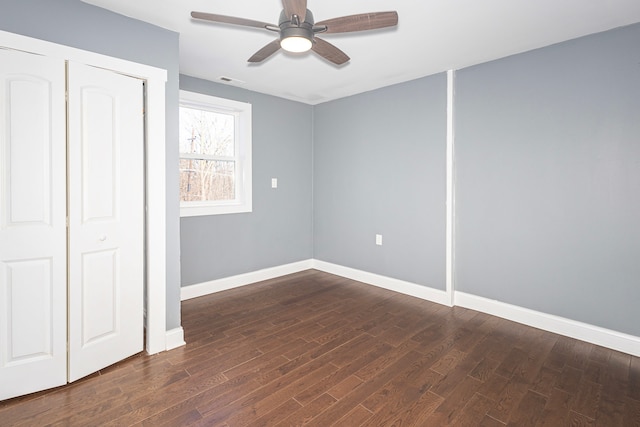 unfurnished bedroom with ceiling fan, dark hardwood / wood-style flooring, and a closet