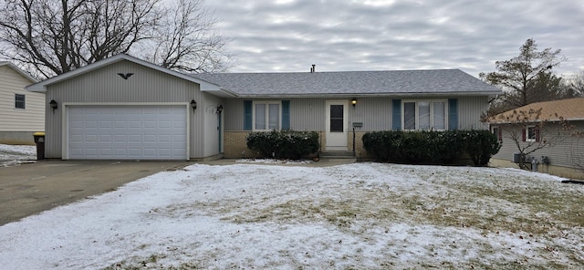 single story home with a garage, driveway, brick siding, and a shingled roof