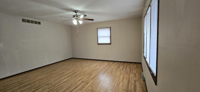 spare room with a ceiling fan, visible vents, and light wood-style flooring