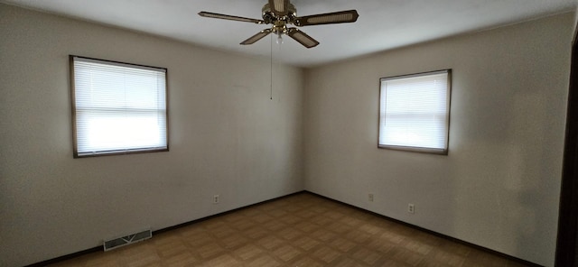 spare room with baseboards, visible vents, ceiling fan, and tile patterned floors