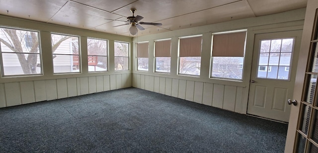 unfurnished sunroom with a ceiling fan and a healthy amount of sunlight