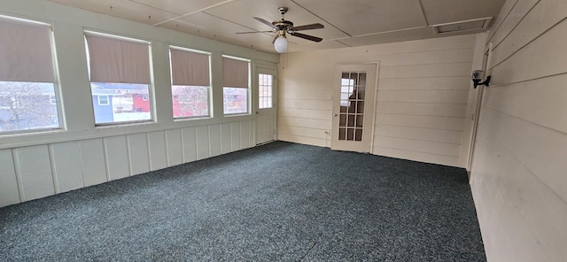 unfurnished sunroom featuring a ceiling fan