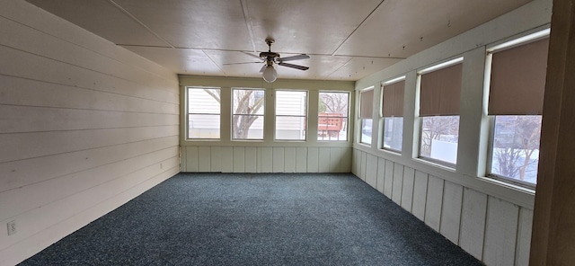 unfurnished sunroom with a ceiling fan and a healthy amount of sunlight