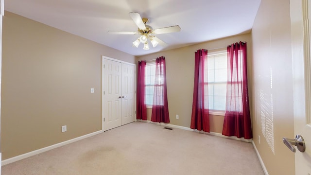 carpeted empty room featuring ceiling fan