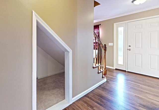 entryway with ornamental molding and dark hardwood / wood-style floors