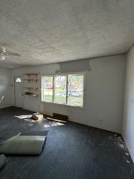 interior space featuring ceiling fan and a textured ceiling