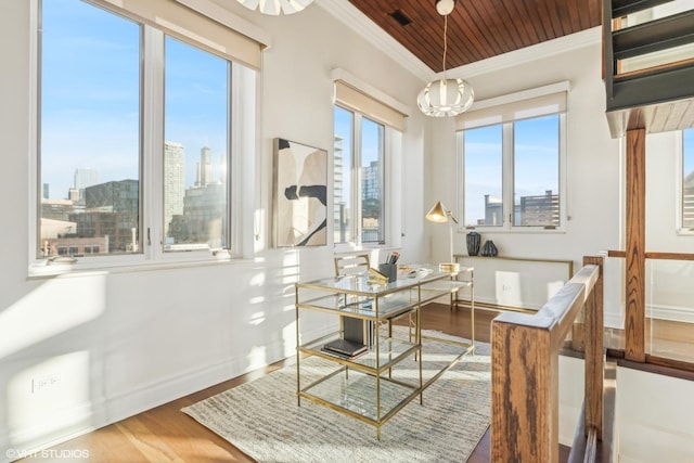 dining area featuring ornamental molding, hardwood / wood-style floors, and a chandelier