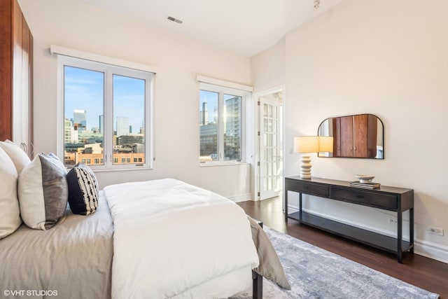 bedroom with dark wood-type flooring and multiple windows