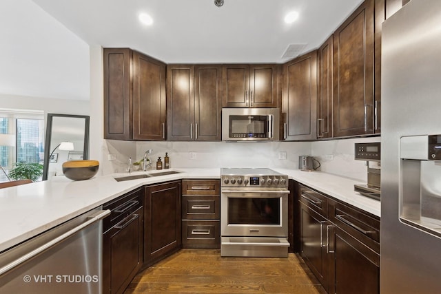 kitchen featuring appliances with stainless steel finishes, sink, dark hardwood / wood-style floors, and dark brown cabinets